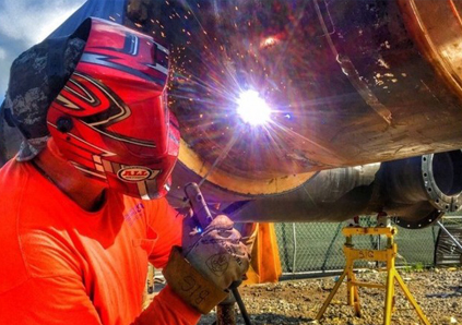 man welding a pipe